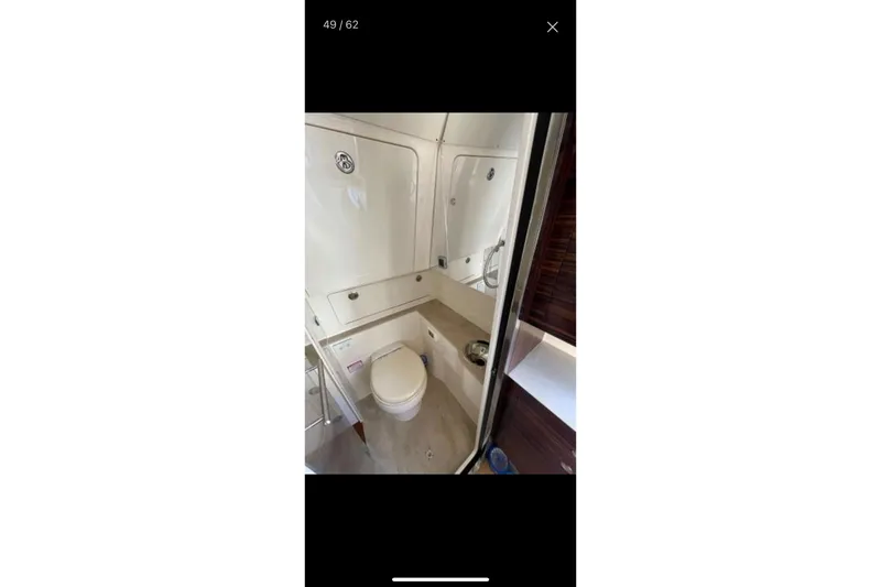 Slide: The Image of 2019 Scout 420 LXF boat bathroom interior with toilet and sink. - 34
