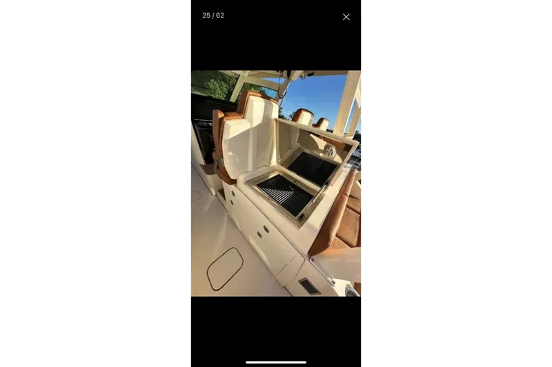 Slide: The Image of 2019 Scout 420 LXF boat with open grill and seating area. - 38