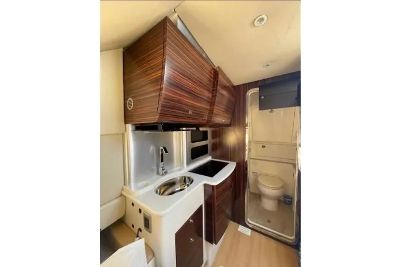 Slide: The Image of Interior of 2019 Scout 420 LXF boat featuring compact kitchen and bathroom area. - 39