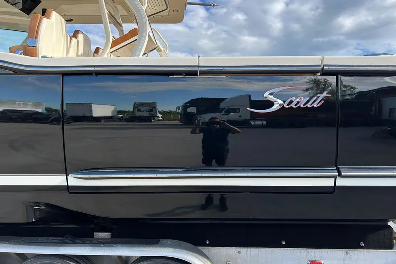 Slide: The Image of 2019 Scout 420 LXF boat side view with logo, reflecting surroundings. - 6