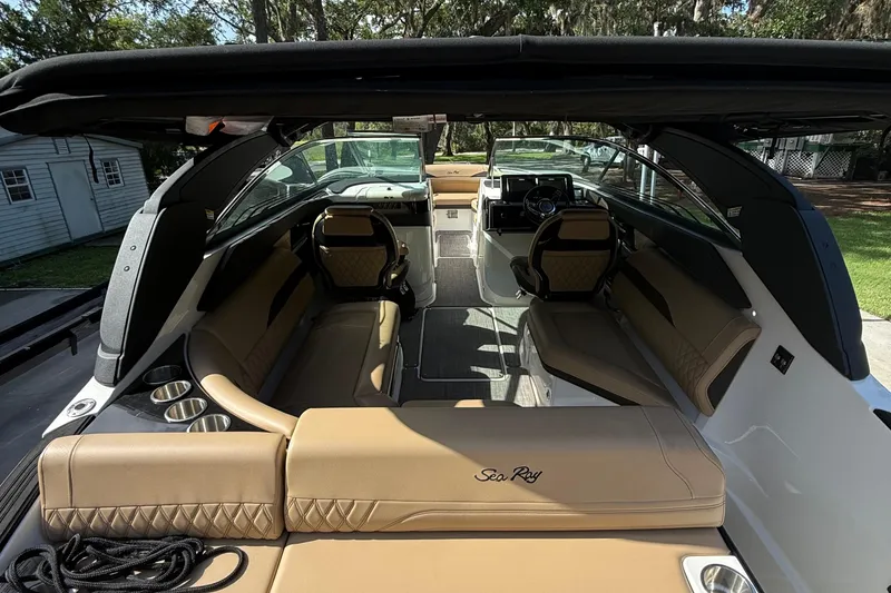 Slide: The Image of 2023 Sea Ray SLX 260 Outboard interior with tan seating and modern dashboard. - 12