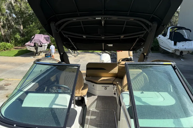 Slide: The Image of 2023 Sea Ray SLX 260 Outboard boat interior with tan seating and open canopy. - 13