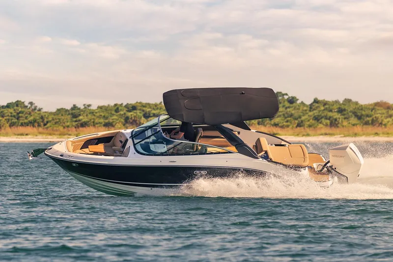 Slide: The Image of 2023 Sea Ray SLX 260 Outboard cruising on water with lush greenery in the background. - 4