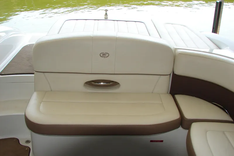 Slide: The Image of 2011 Cobalt 232 boat interior with beige and brown seating near water. - 15