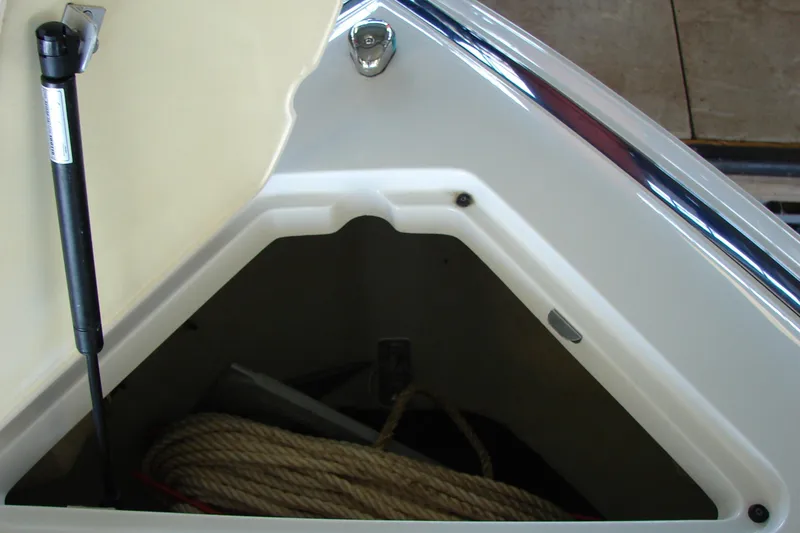 Slide: The Image of Open storage compartment on 2011 Cobalt 232 boat with rope inside. - 23