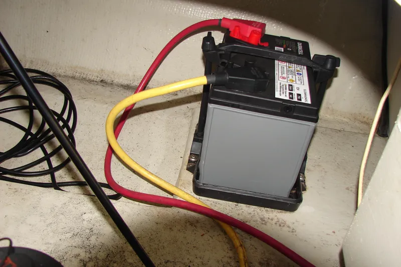 Slide: The Image of Battery with red and yellow cables in a 2011 Cobalt 232 boat. - 27