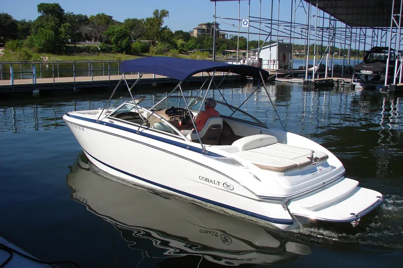 Slide: The Image of 2011 Cobalt 232 boat with canopy, docked on a sunny day at a marina. - 3