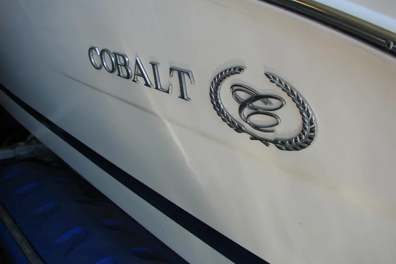 Slide: The Image of 2011 Cobalt 232 boat emblem on white hull. - 38