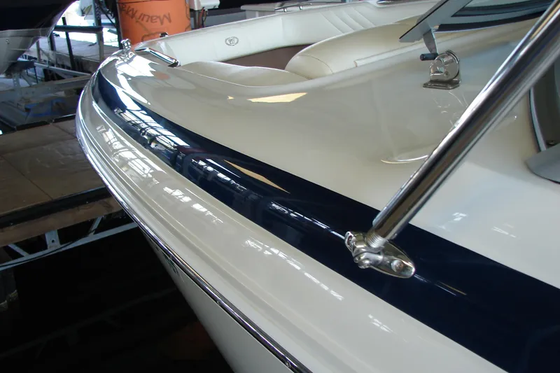 Slide: The Image of 2011 Cobalt 232 boat with sleek white and blue design in a marina setting. - 40