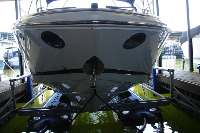 Slide: The Image of 2011 Cobalt 232 boat docked in marina, front view, reflecting water. - 42
