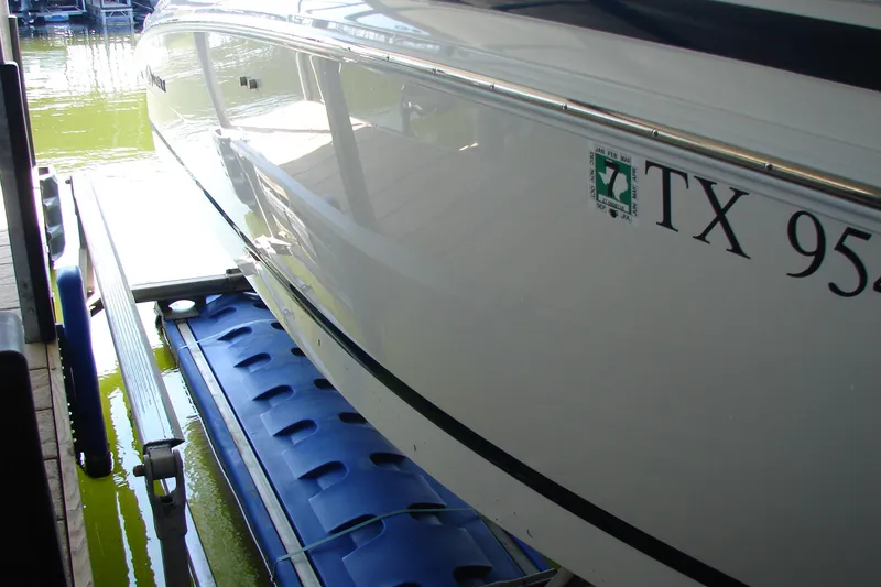 Slide: The Image of 2011 Cobalt 232 boat docked on a blue lift with registration number visible. - 9