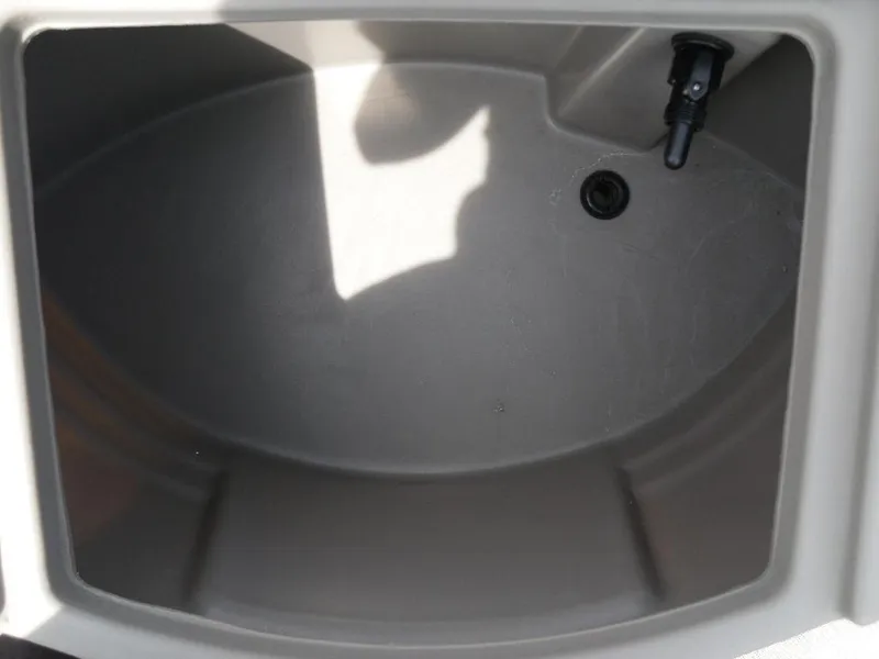 Slide: The Image of 2023 Sun Tracker Sportfish™ 24 XP3 livewell interior, featuring a drain and nozzle. - 22