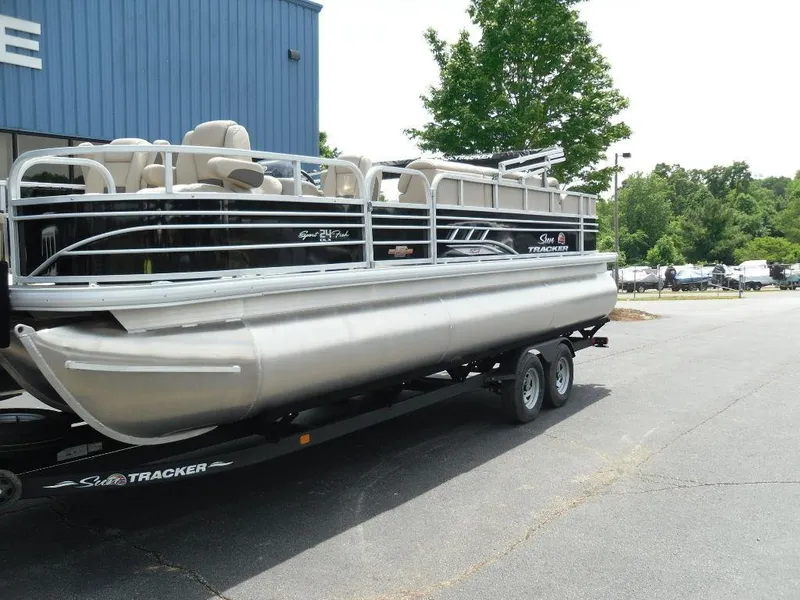 Slide: The Image of 2023 Sun Tracker Sportfish™ 24 XP3 pontoon boat on trailer, parked outdoors. - 3