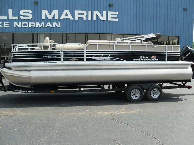 Slide: The Image of 2023 Sun Tracker Sportfish™ 24 XP3 pontoon boat on trailer, parked outside marine dealership. - 6