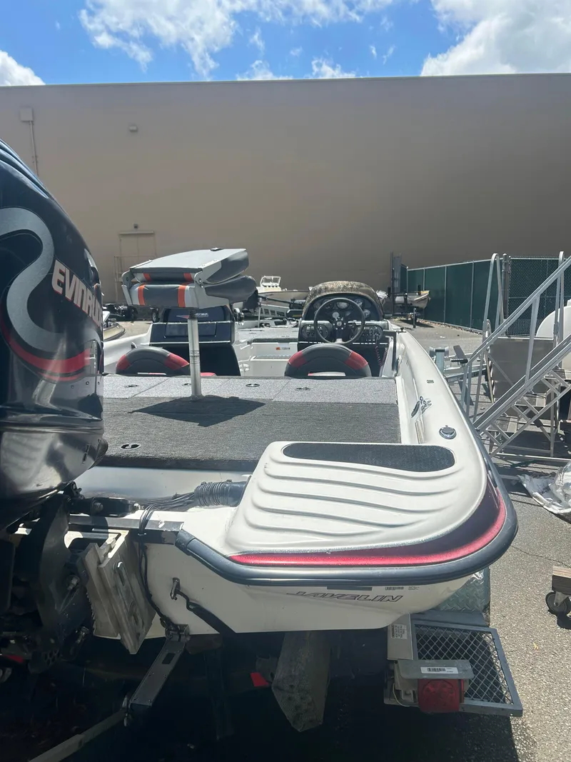 Slide: The Image of 2000 Javelin 20 Renegade boat with Evinrude motor, parked outdoors under blue sky. - 7