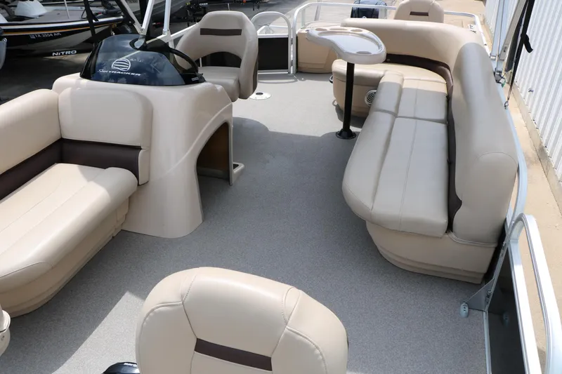 Slide: The Image of 2017 Sun Tracker Fishing Barge 20 DLX interior with beige seating and steering console. - 13