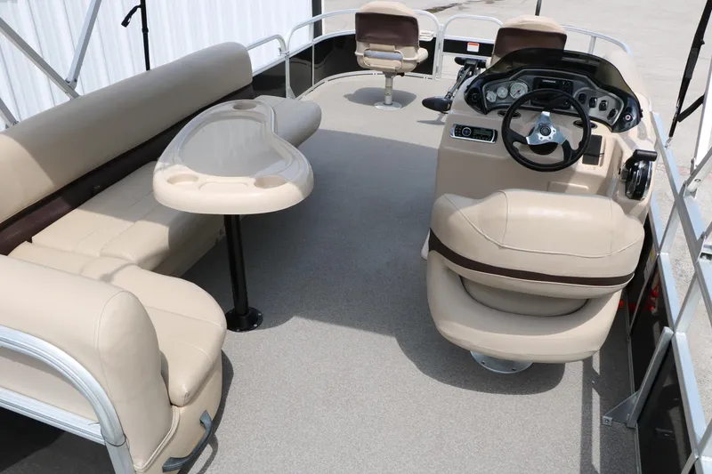 Slide: The Image of 2017 Sun Tracker Fishing Barge 20 DLX interior with beige seating and steering console. - 18