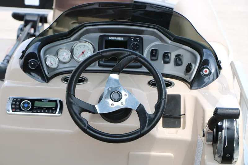 Slide: The Image of 2017 Sun Tracker Fishing Barge 20 DLX dashboard with steering wheel and control panel. - 20