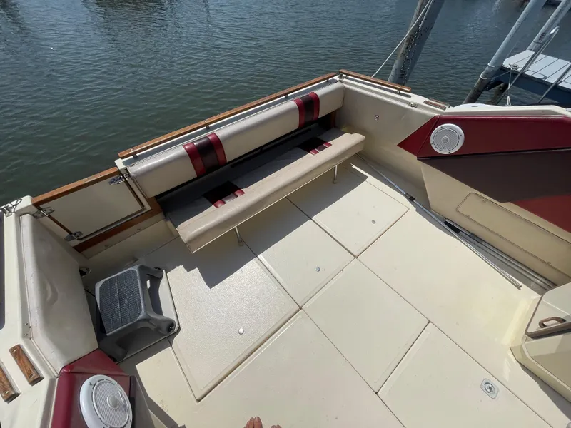 Slide: The Image of 1986 Sea Ray 268 Weekender boat deck with seating and speakers, docked by the water. - 10