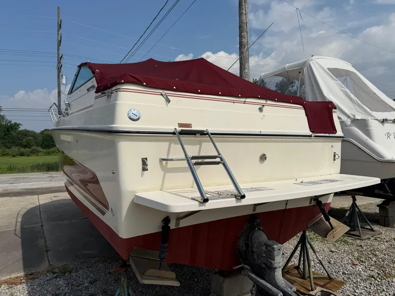 Slide: The Image of 1986 Sea Ray 268 Weekender boat with red canopy, docked on land. - 2