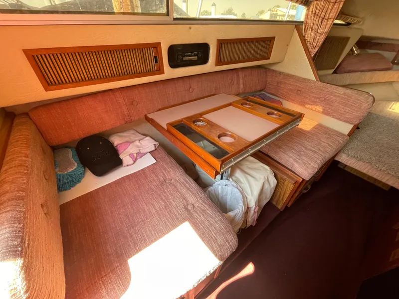 Slide: The Image of 1986 Sea Ray 268 Weekender interior with pink seating and wooden table. - 21