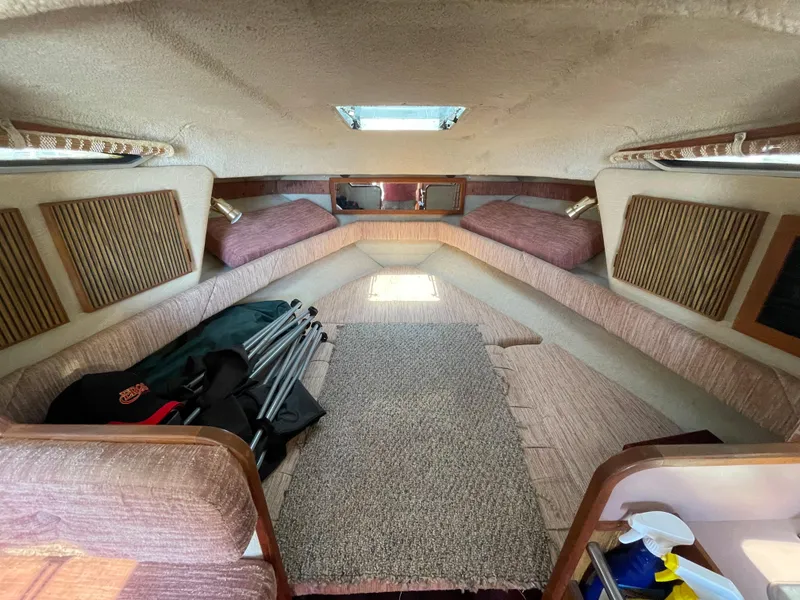 Slide: The Image of Interior cabin of a 1986 Sea Ray 268 Weekender boat, featuring cozy seating and storage. - 22
