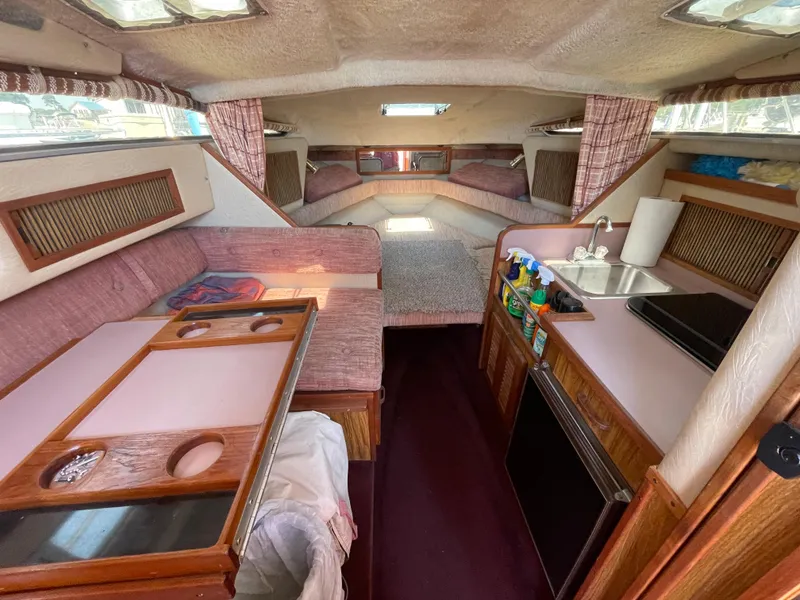 Slide: The Image of Interior of a 1986 Sea Ray 268 Weekender boat with seating, kitchenette, and sleeping area. - 23