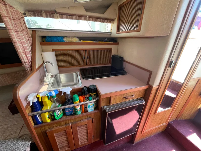 Slide: The Image of 1986 Sea Ray 268 Weekender cabin with kitchenette, sink, and cleaning supplies. - 24