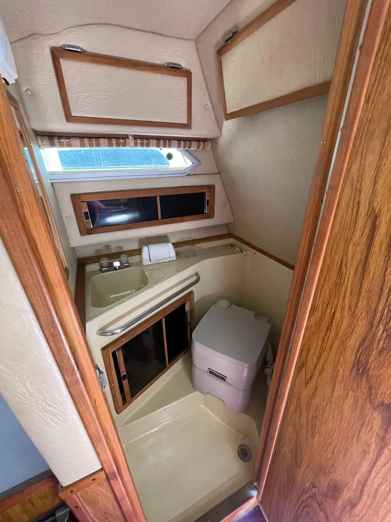 Slide: The Image of 1986 Sea Ray 268 Weekender boat bathroom with sink, toilet, and storage cabinets. - 25