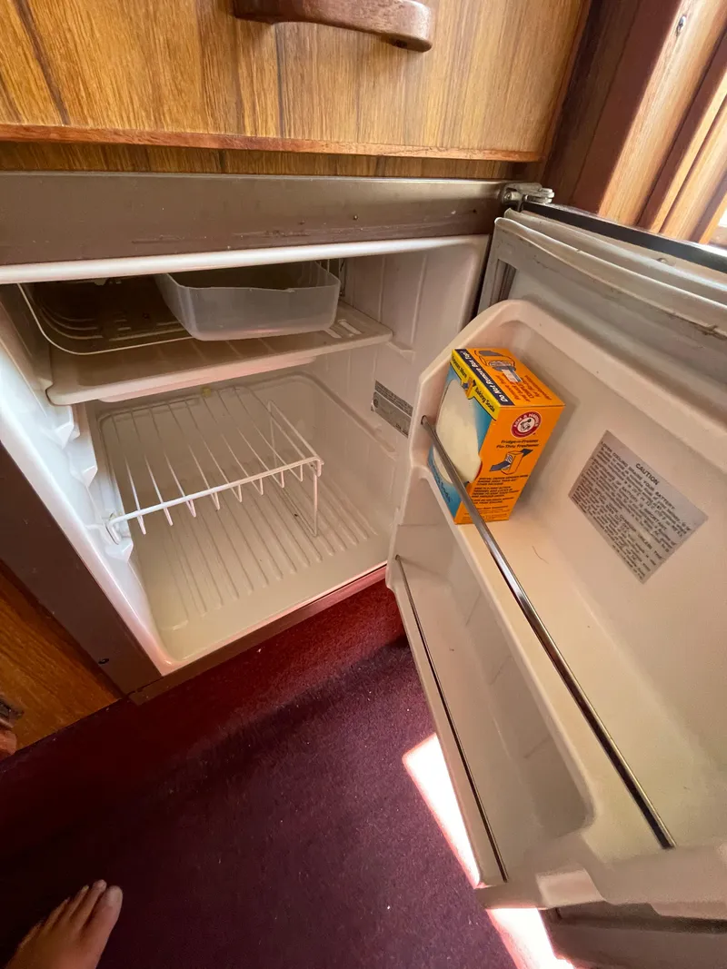 Slide: The Image of 1986 Sea Ray 268 Weekender boat fridge with open door and baking soda box inside. - 27