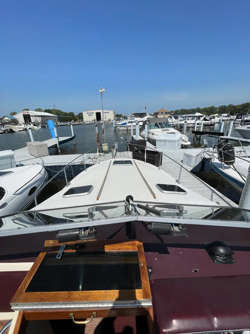 Slide: The Image of 1986 Sea Ray 268 Weekender docked at a marina, surrounded by other boats. - 28