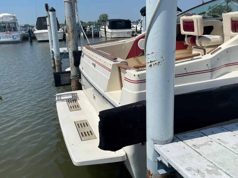 Slide: The Image of 1986 Sea Ray 268 Weekender docked at marina, showcasing rear deck and seating. - 31