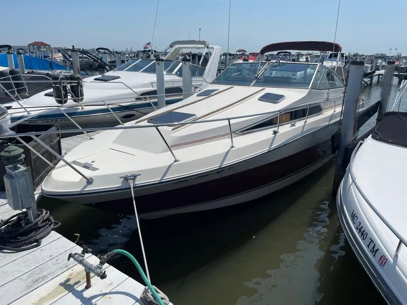 Slide: The Image of 1986 Sea Ray 268 Weekender docked at marina, surrounded by other boats. - 4