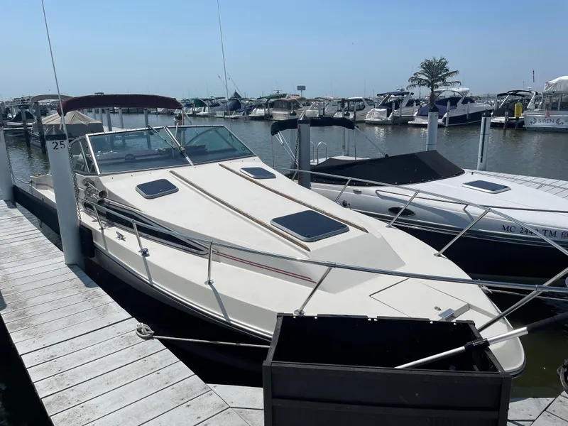 Slide: The Image of 1986 Sea Ray 268 Weekender docked at marina, surrounded by other boats. - 7