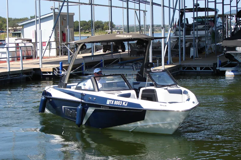 Slide: The Image of 2021 Malibu Wakesetter 22 LSV boat docked at marina, sunny day. - 12