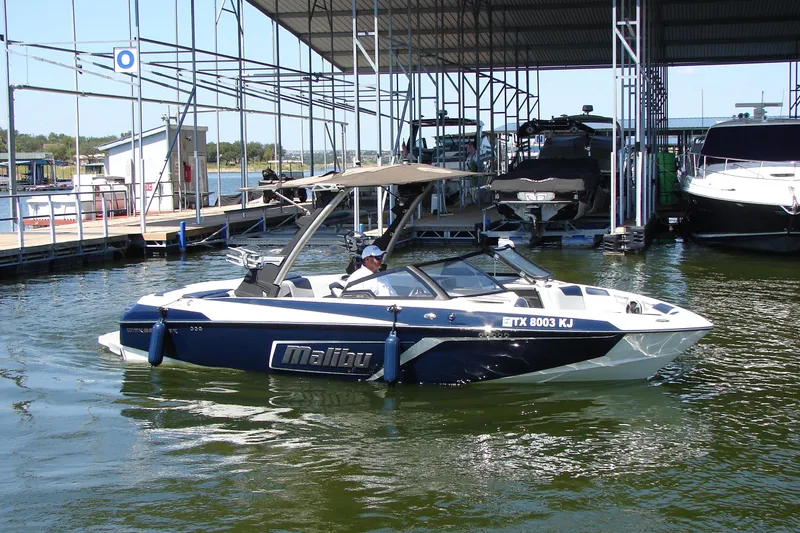 Slide: The Image of 2021 Malibu Wakesetter 22 LSV boat docked at a marina, featuring sleek design. - 13