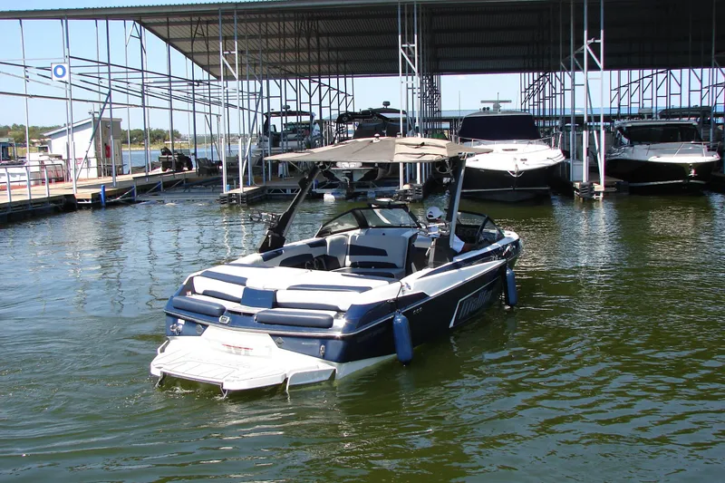 Slide: The Image of 2021 Malibu Wakesetter 22 LSV docked at marina, surrounded by other boats. - 16
