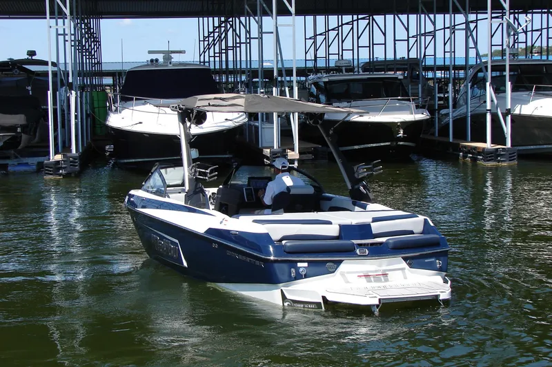 Slide: The Image of 2021 Malibu Wakesetter 22 LSV boat docked in marina, surrounded by other vessels. - 17