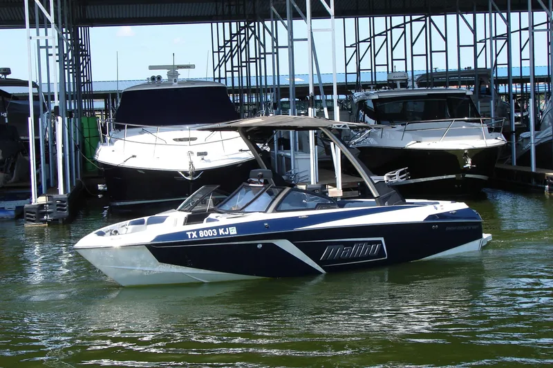 Slide: The Image of 2021 Malibu Wakesetter 22 LSV boat docked in marina, surrounded by other vessels. - 20