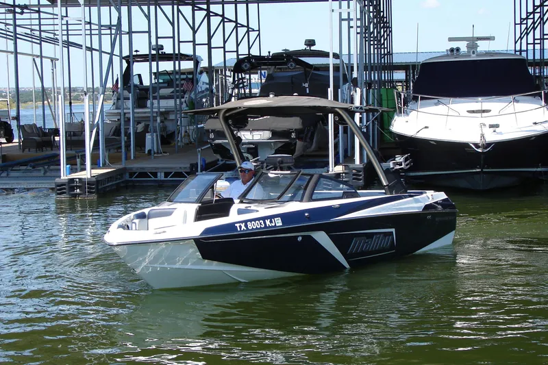 Slide: The Image of 2021 Malibu Wakesetter 22 LSV boat docked at marina, calm water, sunny day. - 21