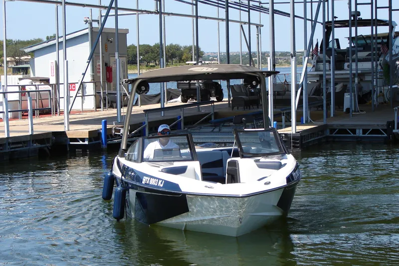 Slide: The Image of 2021 Malibu Wakesetter 22 LSV boat docked at a marina. - 22