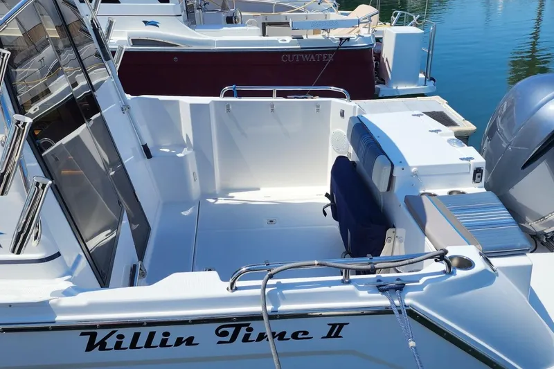 Slide: The Image of 2019 Cutwater C-24 Coupe boat docked, featuring spacious deck and sleek design. - 10