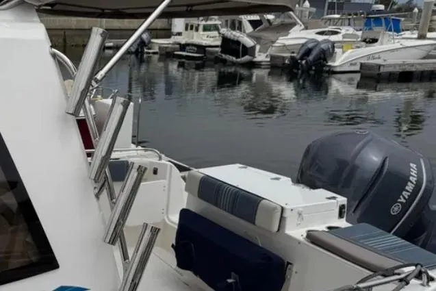 Slide: The Image of 2019 Cutwater C-24 Coupe docked with Yamaha outboard motor, marina background. - 13