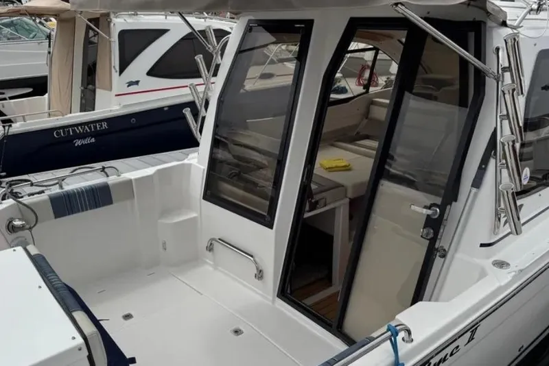 Slide: The Image of 2019 Cutwater C-24 Coupe boat with open cabin door, docked in marina. - 15