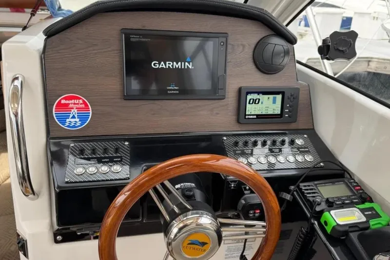 Slide: The Image of 2019 Cutwater C-24 Coupe dashboard with Garmin display and wooden steering wheel. - 21