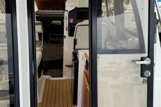 Slide: The Image of 2019 Cutwater C-24 Coupe interior view with open door, showcasing seating and dashboard. - 25