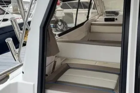 Slide: The Image of 2019 Cutwater C-24 Coupe interior with seating and helm, docked at marina. - 26