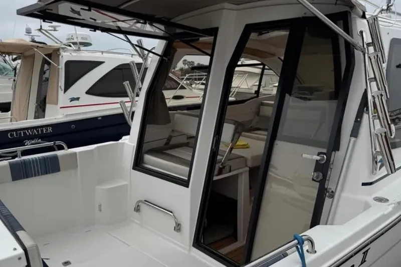 Slide: The Image of 2019 Cutwater C-24 Coupe boat with open cabin door, docked at marina. - 27
