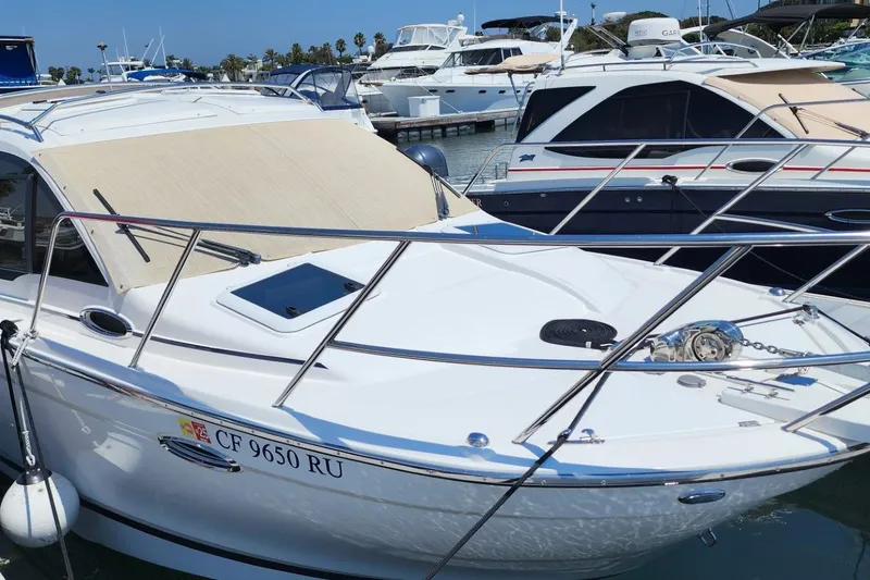 Slide: The Image of 2019 Cutwater C-24 Coupe docked at marina, surrounded by other boats. - 3