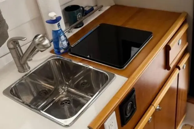 Slide: The Image of 2019 Cutwater C-24 Coupe kitchenette with sink, faucet, and stove. - 30